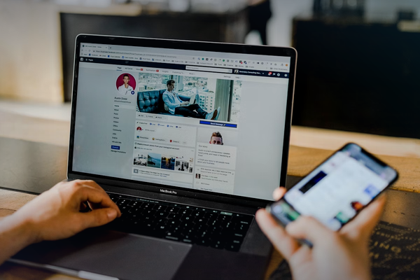 Business workspace with laptop and smartphone for website versus social media article